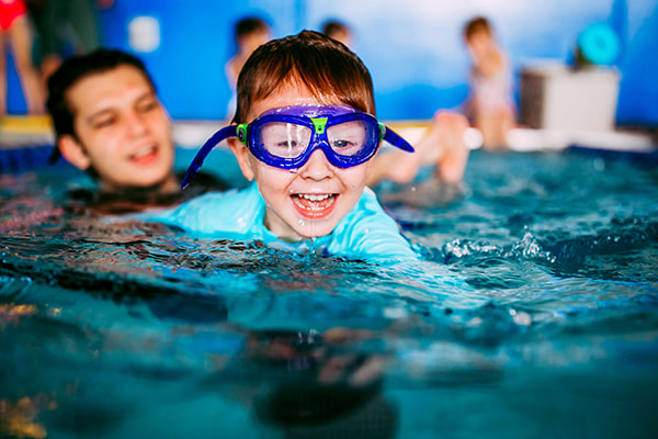boy with swim goggles taking lesson