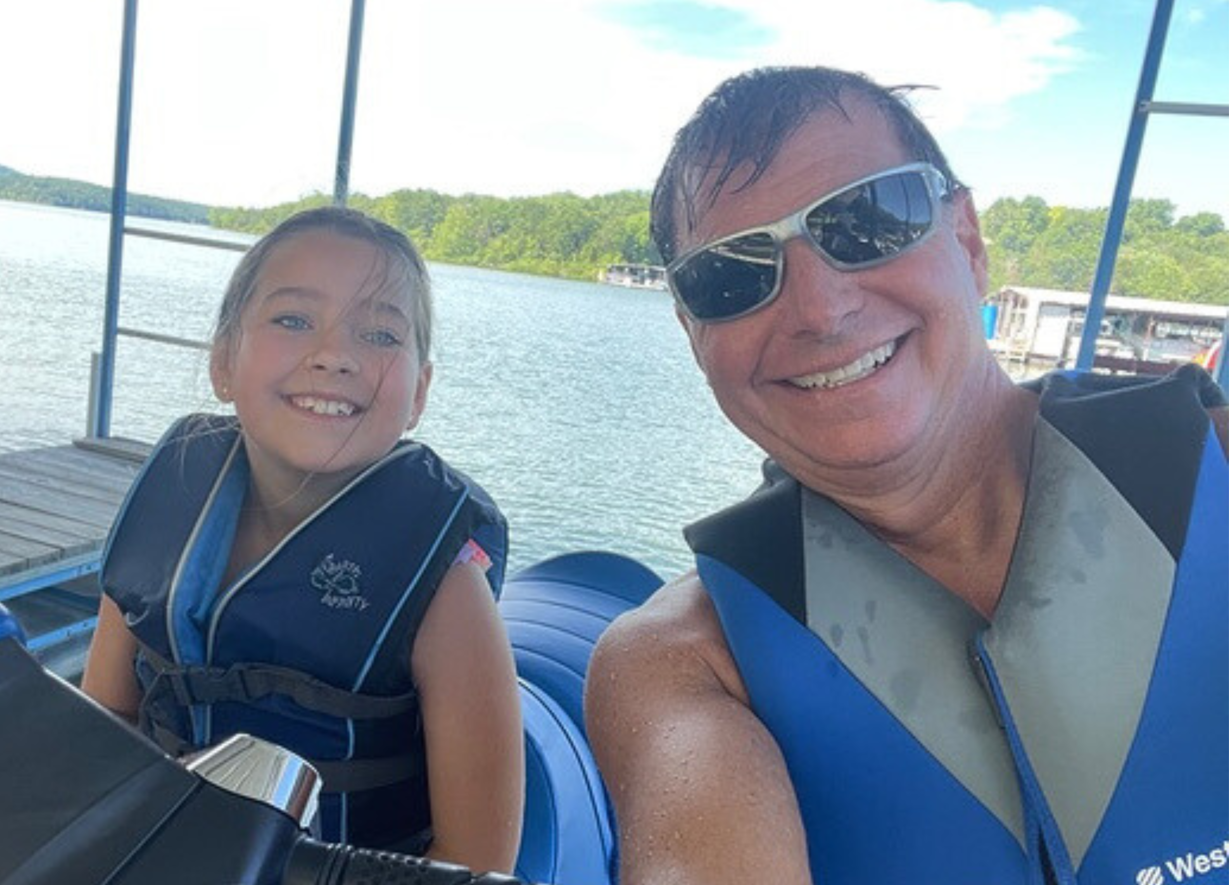 man and girl wearing life jackets while on jet skis