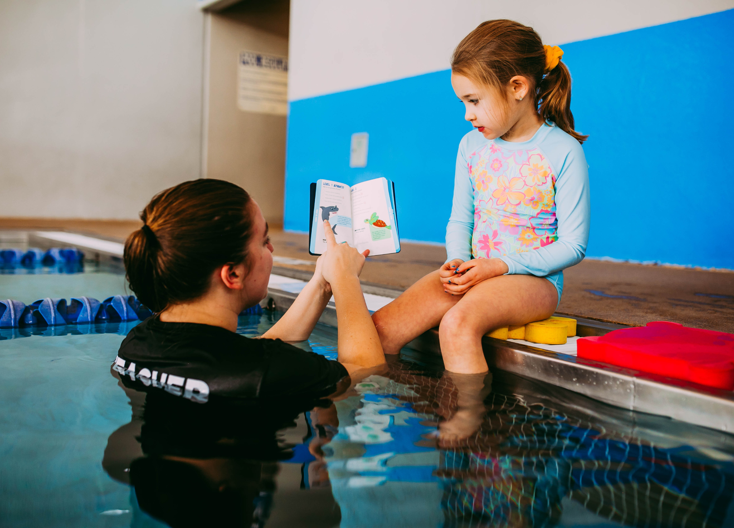 swim teacher going over the Passport to Adventure with student